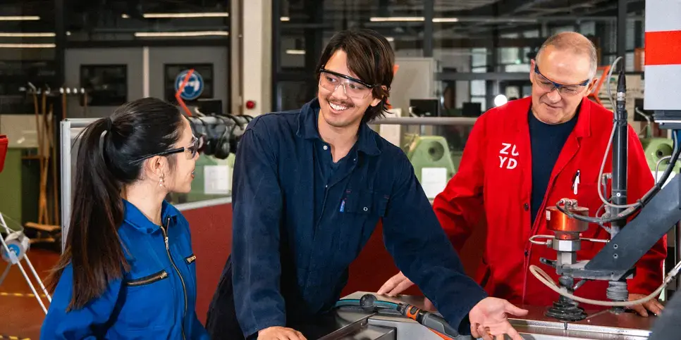 Twee studenten krijgen uitleg van een docent