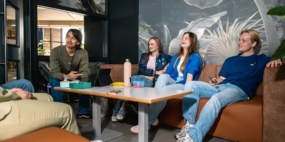 Studenten aan tafel in gesprek met wat eten
