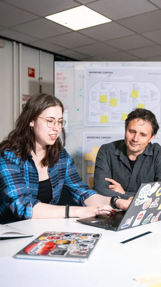 CMD - docent helpt leerling achter laptop