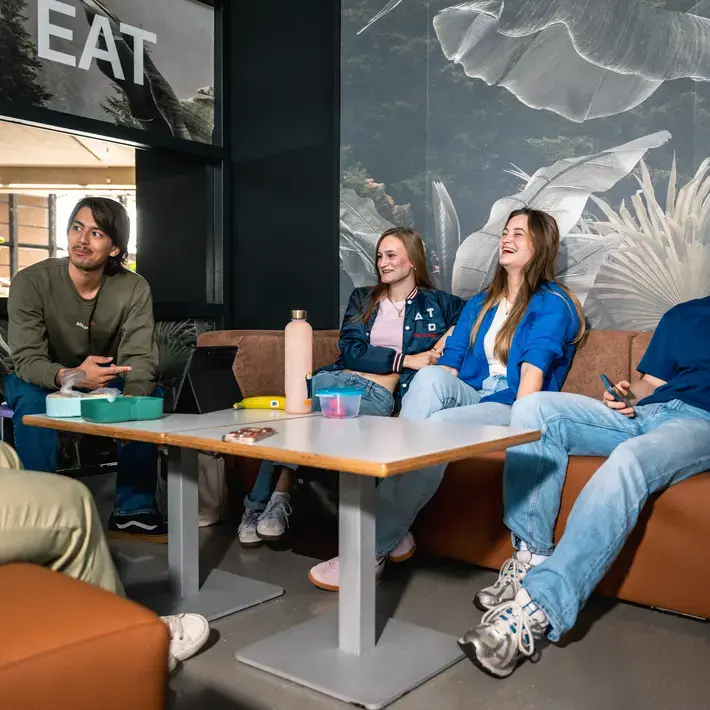 Studenten aan tafel in gesprek met wat eten