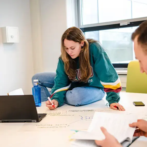 Ergotherapie - student zit op tafel