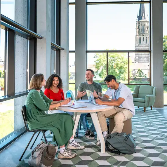 Social-Work studenten aan tafel in hal
