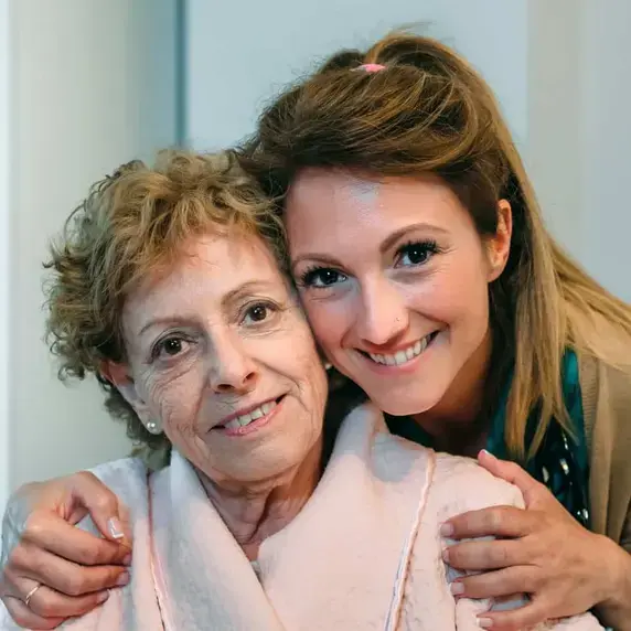 Oudere vrouw in stoel met zorgverlener