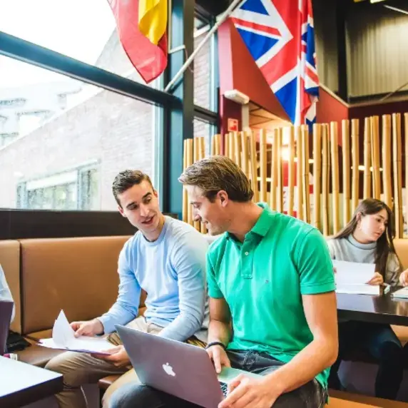 European Studies 3 jongens 2 meiden met laptop vlaggen in kantine 750x500.jpg