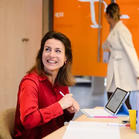 Zuyd Professional dame in rode blouse aan bureau.jpg