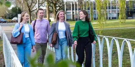 Hotel Management - 4 studenten lopen over brug