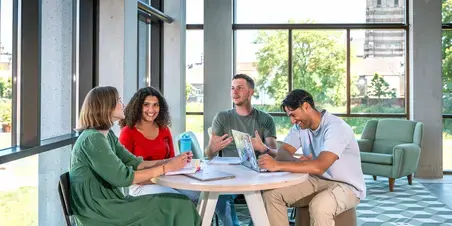 Social-Work studenten aan tafel in hal