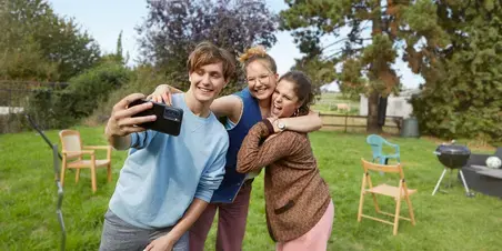Drie studenten maken een foto tijdens een barbeque