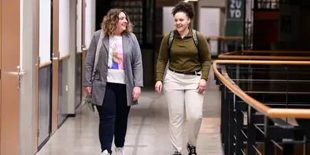 Twee cursisten lopend door Zuyd Hogeschool