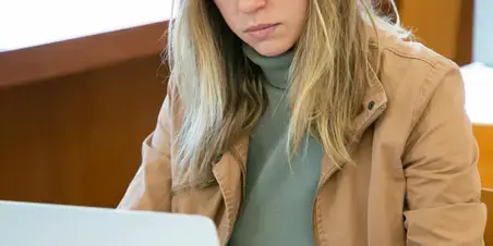 Vrouw die voor een laptop zit.